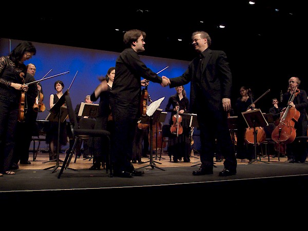 Aaron Boyd, concertmaster, Karchin, and the orchestra